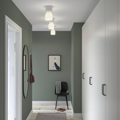 Modern grön hall med HAMNFYR lampor, stol, spegel och garderob.