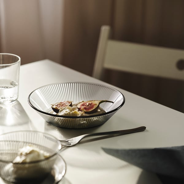 Dukning med fruktskål och glas vatten.