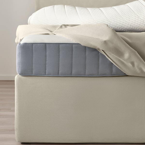 En HEMFJÄLLET divansäng med två förvaringslådor under sängen. Sängen har ett avtagbart överdrag som kan tvättas i maskin och en stoppad design.