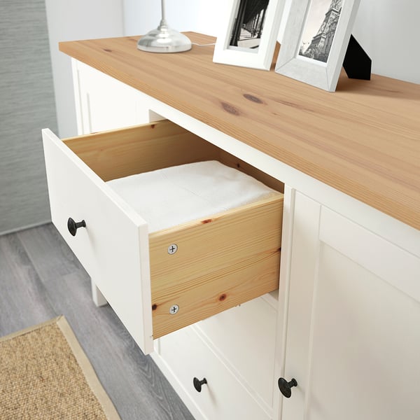 Öppen trälåda av vit HEMNES skänk, som visar invändiga fack.