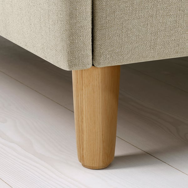 Hantverksmässigt sängben i närbild, robusta ljusa trästöd plyschklädd ram på elegant golv.