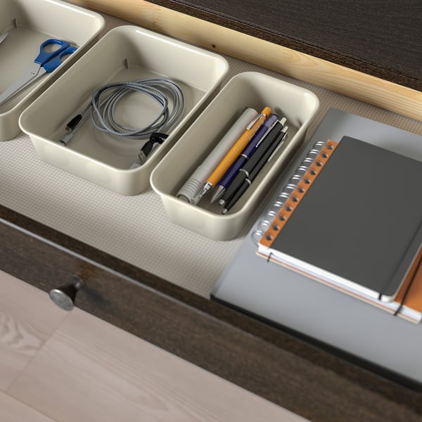 Organiserat skrivbord med inbyggd kabelhantering. Lådorna rymmer laddningskablar, pennor och anteckningsbok.