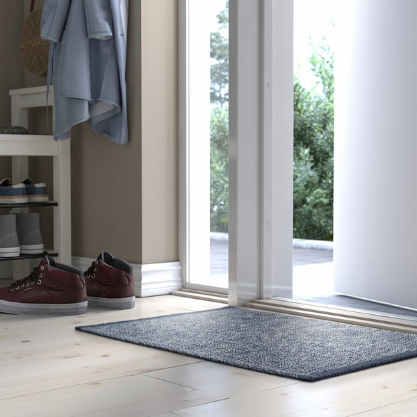 Mörkblå IDROTTSPLATS matta nära dörren, bomull, absorberande, kompletterar golvet.