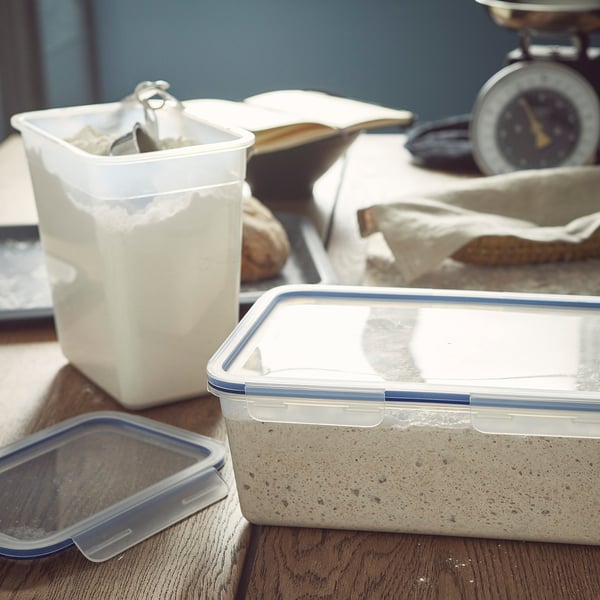 Plastbehållare på trä, som håller pulver och grå substans.