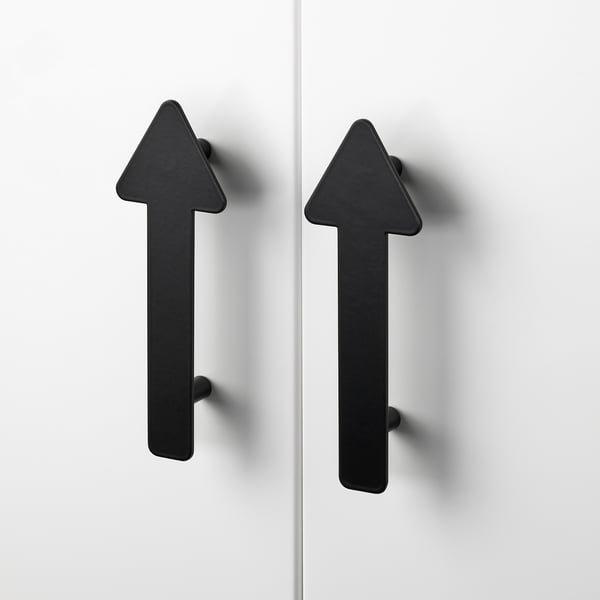 Två moderna, minimalistiska svarta pilformade handtag fästa på vita skåpdörrar. Högkvalitativ, elegant finish med robust design.