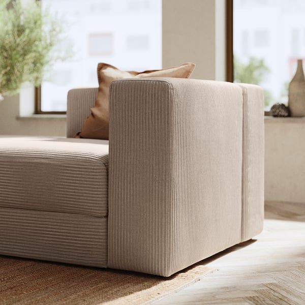 Modern beige soffa med ribbad struktur, minimalistisk design.
