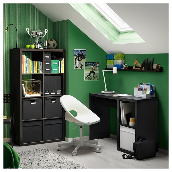 Mysig studieplats med gröna väggar, svart skrivbord KALLAX, vit stol, sportfoton, lampa, böcker och ett litet akvarium.