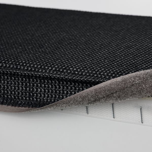 Närbild på KIVIK fotpallar, texturerat tyg och kardborrestängning, som visar design och förvaringsutrymme som är lätt att rengöra.