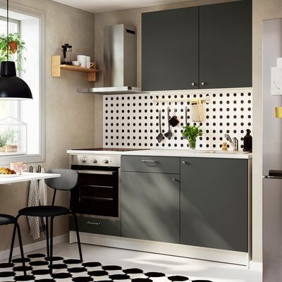 KNOXHULT mörkgrått köksset med bänkskiva i marmor, minimalistisk design under svart pendel.