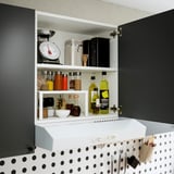 Väggskåp med justerbar hylla, förvaring av köksartiklar som kryddor, oljor och en våg.