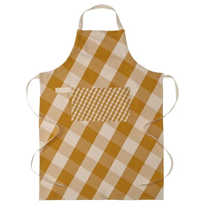 Förkläde med namnet KÖSSEBÄR, med gul- och vitrutig design, med justerbara axelband och en framficka, tillverkad av 100% bomull.