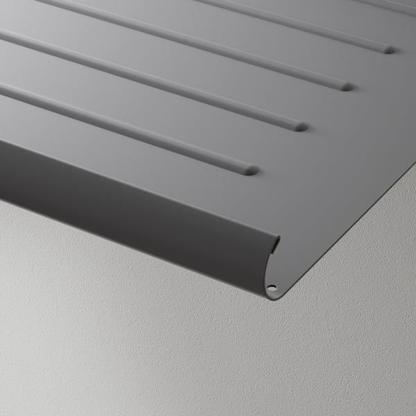 Modern, metallgrå hylla med lutande design och fasad kant, perfekt uppställd mot en ren vägg.