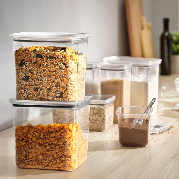 Plastburkar med KORALLVIPPA med flingor, staplade på trä, visar organiserad förvaring i köket.