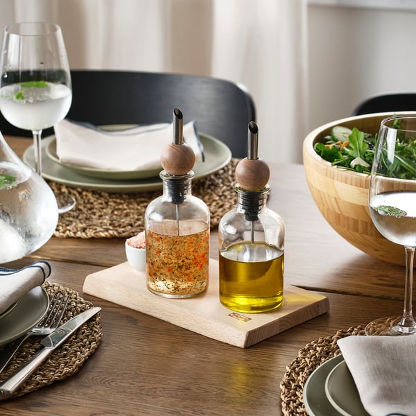 Droppproppar av trä på glasflaskor förhindrar spill. Ställ in med tallrikar, glas och sallad.
