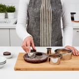 Person som skär tårta med LÄTTBAKAD-skärare på trä