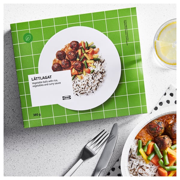 Ikeas LÄTTLAGAT-låda visar grönsaksbollar, ris, grönsaker och currysås; redo att värmas.