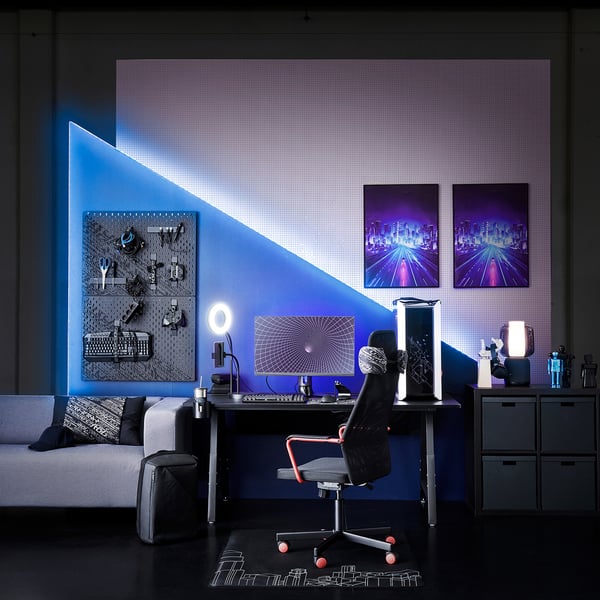 Modern speluppsättning med blått neontema: skrivbord, stol, bildskärm, tangentbord och ringlampa med telefonhållare.