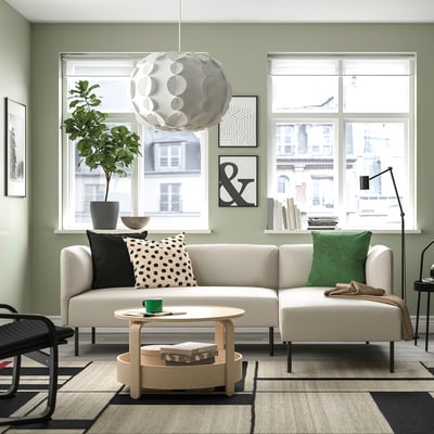 Modernt vardagsrum med soffan LILLEHEM beige, salviaväggar och utsikt över staden.