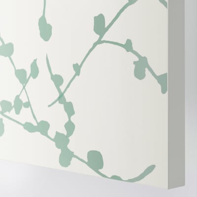 Illustrativa konstverk på möbler, minttoner, vit bas, subtil inredning.