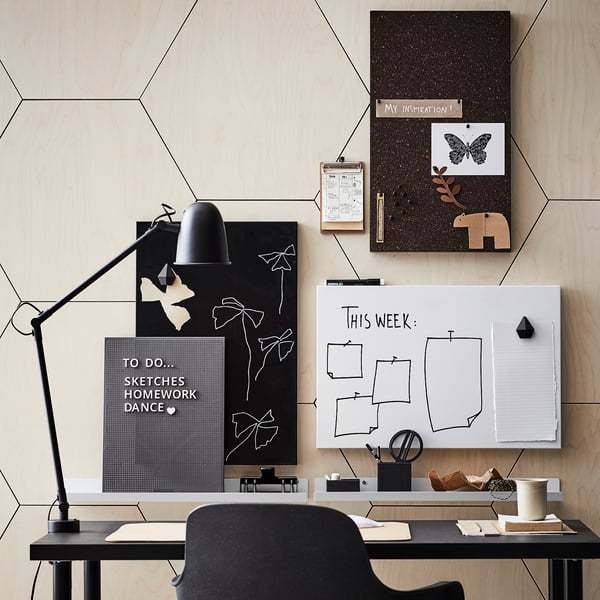 Modern arbetsyta med LINNMON skrivbord, svart, stor, geometrisk vägg, whiteboard, korkbräda, lampa, stol, inredning.