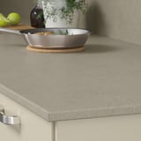 Köksbänk med bänkskiva i grått återvunnet glas med kastrull och limefrukter.