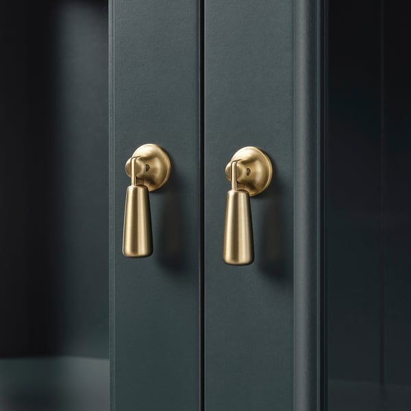 Mörka dubbeldörrar i trä med eleganta, guldfärgade handtag, som återspeglar kvalitet och modern design.