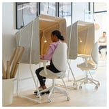 Kvinna i ljudisolerad MITTZON kontorspod med bärbar dator.