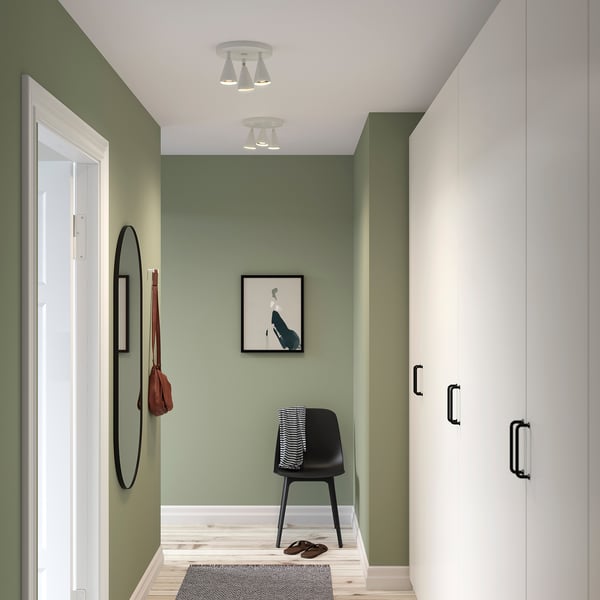 Modern grön hall med svart stol, spegel och NÄVLINGE-lampor.