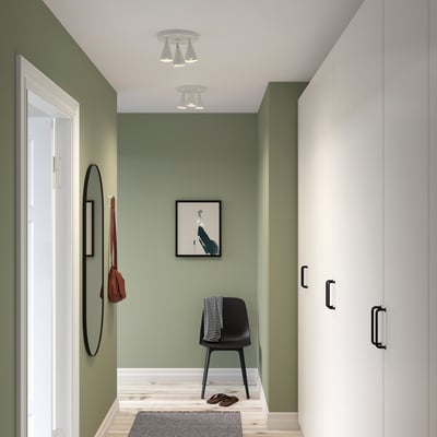 Modern grön hall med svart stol, spegel och NÄVLINGE-lampor.