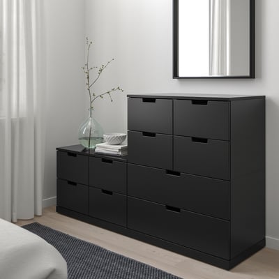 Svart NORDLI byrå med 6 lådor i det minimalistiska sovrummet.