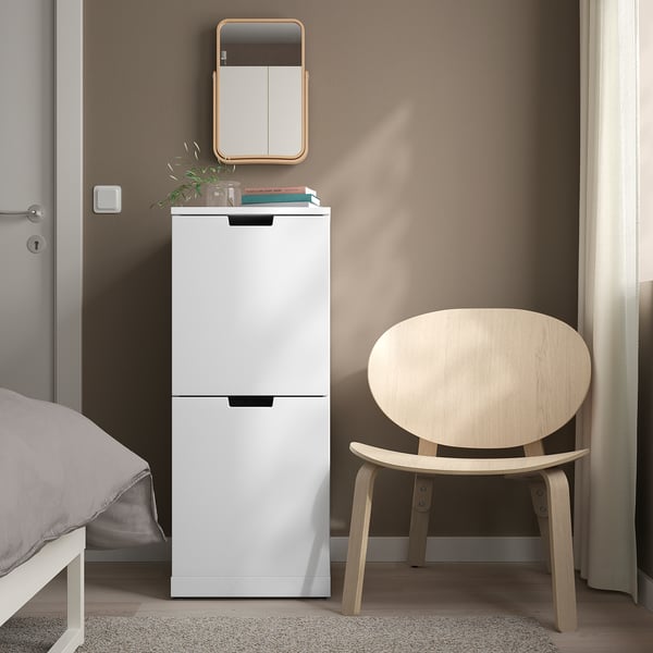 Vit IKEA NORDLI byrå med 2 lådor mellan säng och stol, minimalistisk hörna.