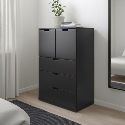 Modern svart NORDLI byrå i sovrummet, högre än mattan, med lådor och skåp.