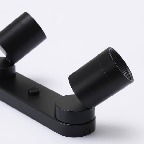 Svart modern justerbar spotlightarmatur med eleganta, cylindriska lampor.