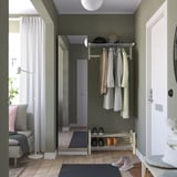 Modern entré med olivfärgade väggar, vit dörr, klädhängare, skohylla och grå matta. PAX garderob står högt bredvid dörren.