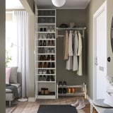 Entré med skoförvaring, klädhängare, bänk och spegel. Ljusa väggar, trägolv, mörk matta.