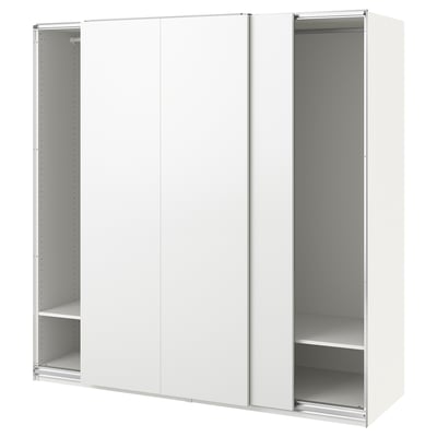 En vit ikea PAX garderob med skjutdörrar och öppna hyllor.