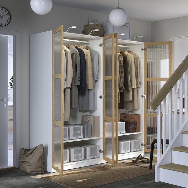 Modernt dörrskåp med kläder och hyllor, med elegant design, integrerad belysning och organiserade förvaringsfack.