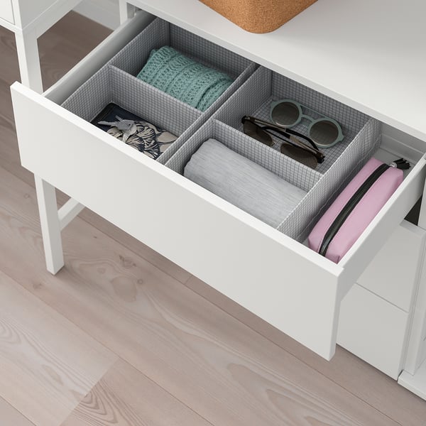 Öppen vit PLATSA-lådsats som visar organiserad förvaring av kläder, accessoarer och diverse föremål. Inkluderar nätavdelare och en rosa påse.