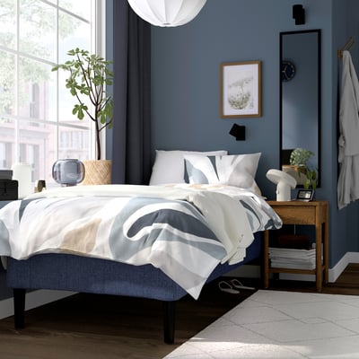 Modernt sovrum med blå och vit säng RÅHOLMAR , elegant och minimalistiskt.