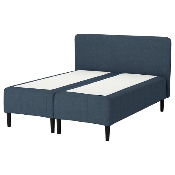 En blå klädd sängram med sänggavel, vit madrass, mörka träben och en modern design.