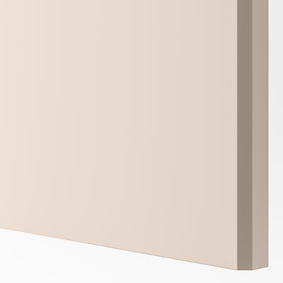 Närbild på en mjuk beige skåpdörr i återvunnet material. Synlig slät kant och matt finish, som framhäver sin högkvalitativa struktur.