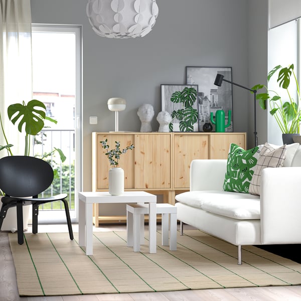 Benvit matta med gröna rutor i modernt vardagsrum.