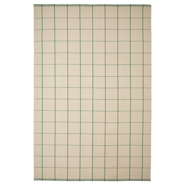 En rektangulär matta RIDSTIG med ljusbeige bakgrund och gröna vertikala ränder. Den är gjord av bomull och lämpar sig för matplatser.