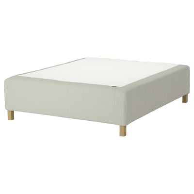 Vit stoppad sängbotten med träben, elegant och modern.