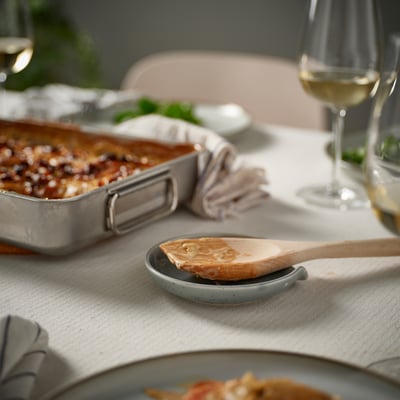 Köksbord med ugnsbak, vinglas och skedstöd.