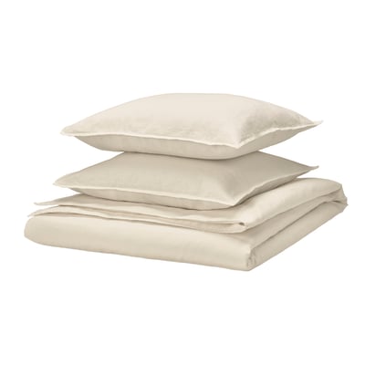 Ett vikt beige sänglinneset, bestående av ett påslakan och örngott, snyggt staplade, med en kuvertstängningsdesign.