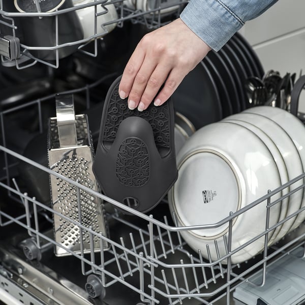 Placera svart SANDVIVA värmebeständig silikonbricka för hand i diskmaskinen.