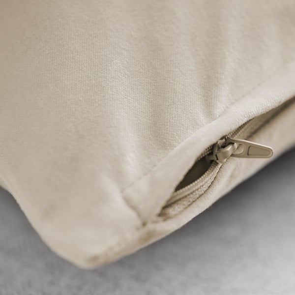 Närbild av ett plyschigt kuddfodral i beige bomullssammet med en dragkedja av hög kvalitet, som framhäver dess mjuka struktur och släta finish.