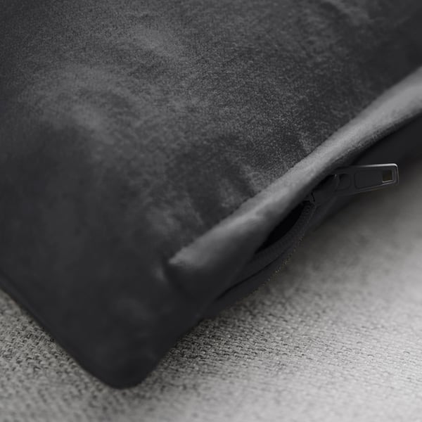 Närbild av mjukt, texturerat kuddfodral i rik sammet, säkrat med en dragkedja i metall.