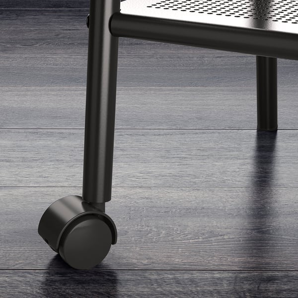 Modernt sängbord i metall med hjul, med perforerad hylla, på elegant trägolv. Kvalitet och design.